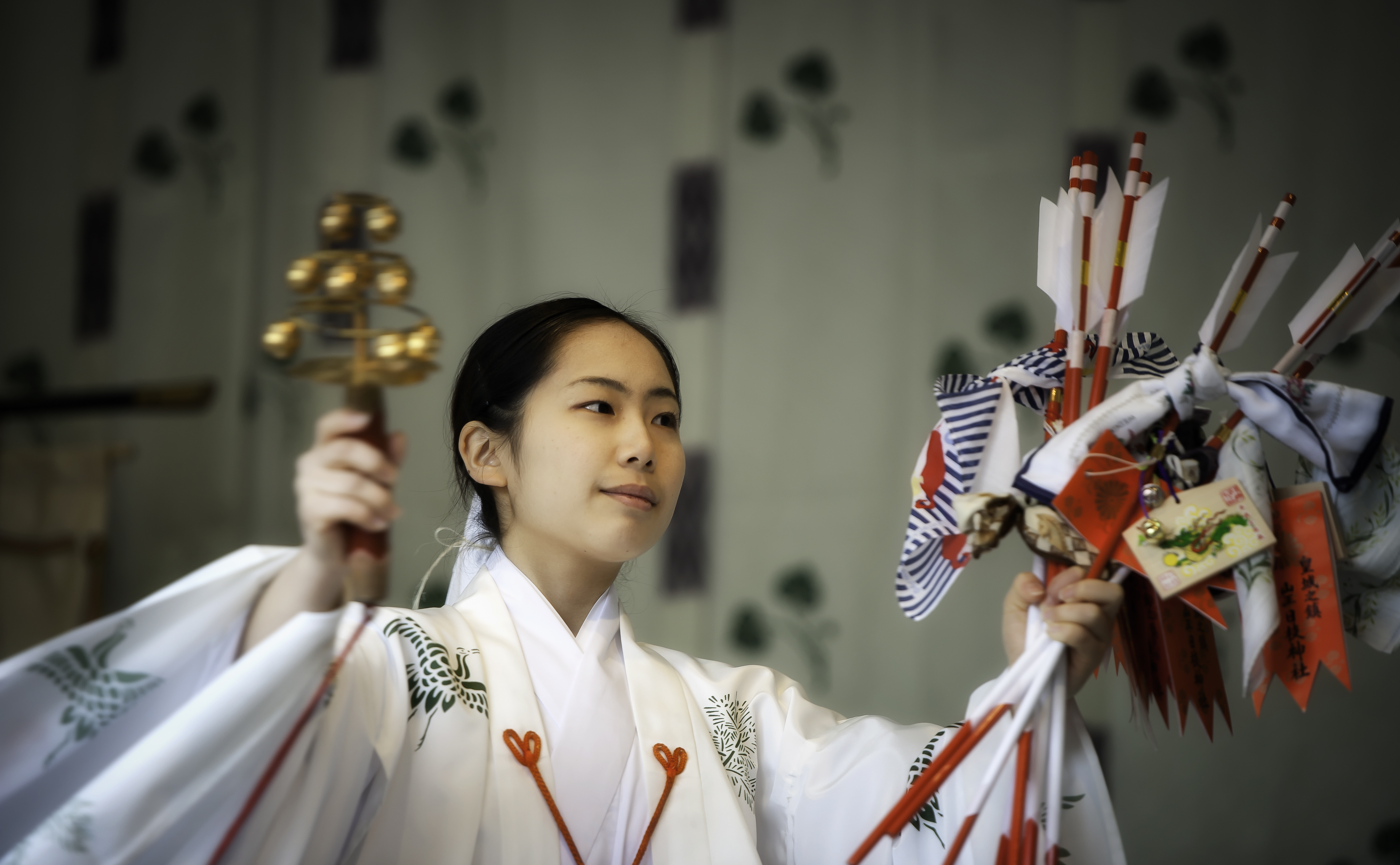 A shinto miko carrying a handful of hamaya arrows on New Year